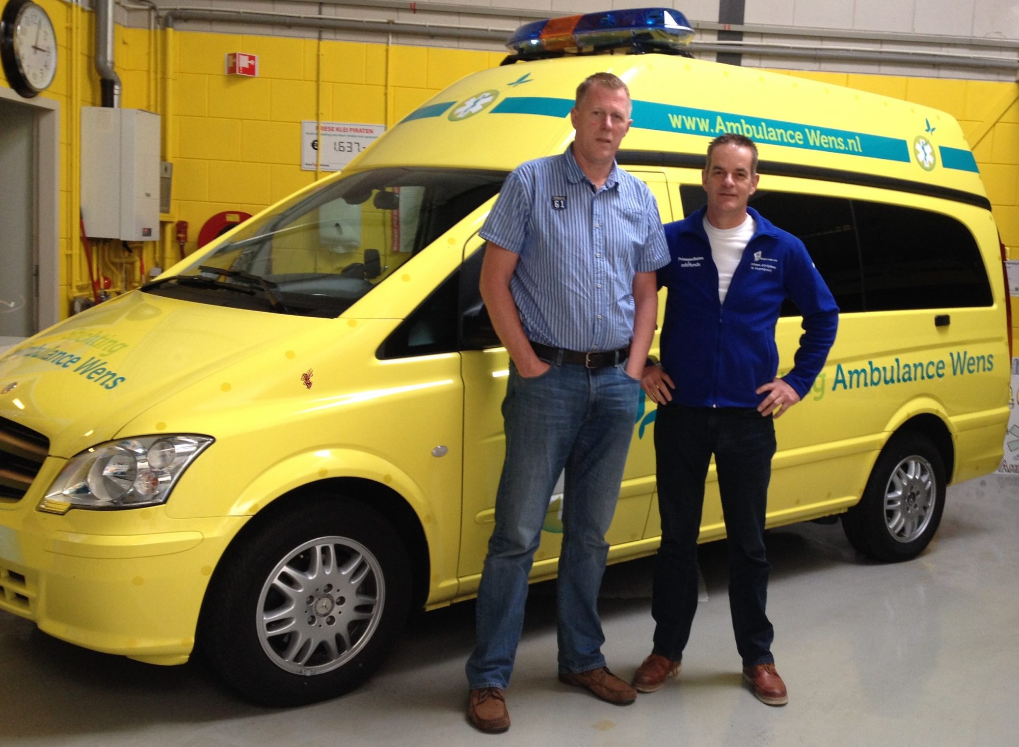 Beide voorzitters van Ambulancewens en Topsport for Life, Kees Veldboer en Miel in 't Zand, poseren bij de nieuwste ambulance.